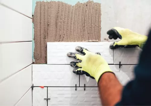 Contractor retiling a wall during a Bathroom Remodel in Bloomington IL