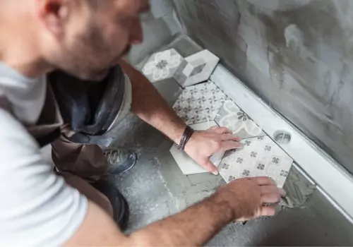 A contractor placing tiles during Bathroom Renovations Near You