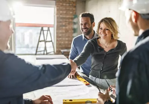 Happy couple shaking hands with their contractors, who are building custom homes in Illinois