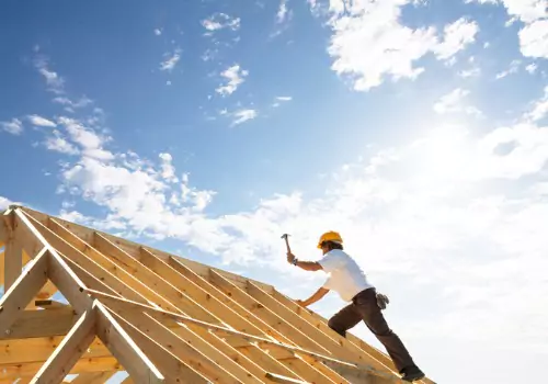 A worker on the roof, helping construct new Custom Homes in Normal IL